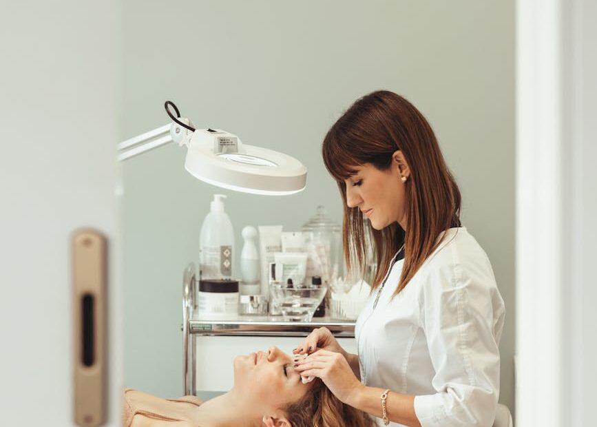 beautician making facial beauty procedures for woman in salon
